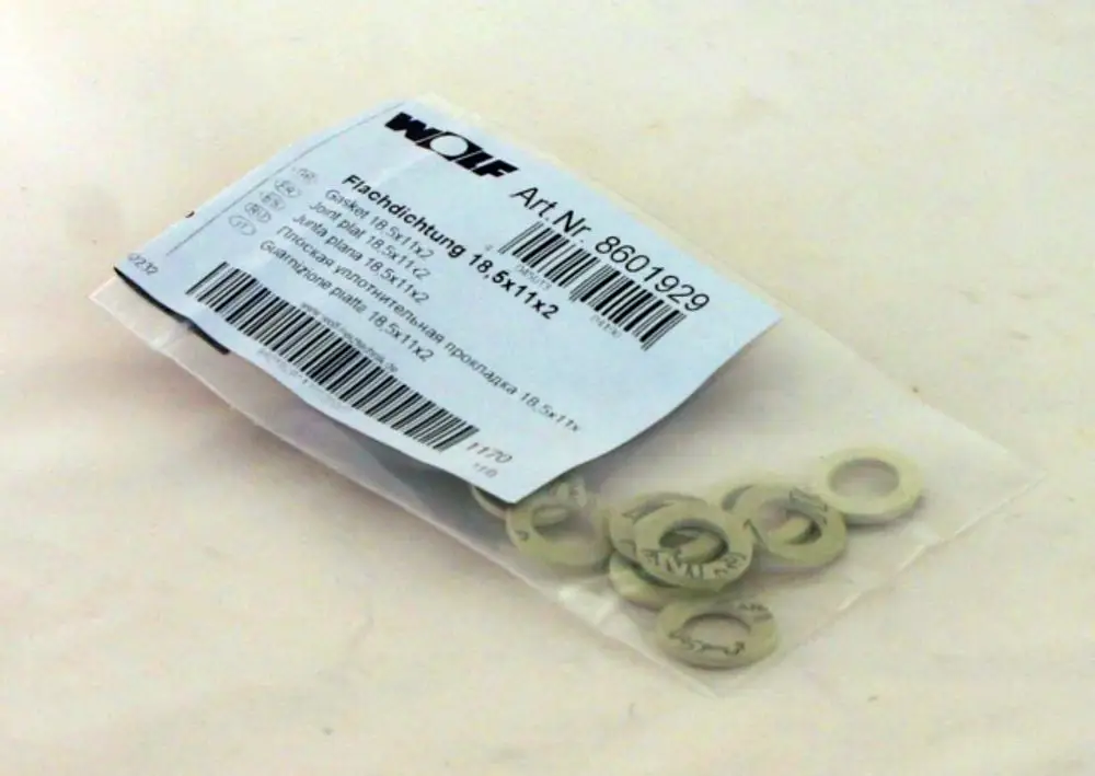 Verpackung mit mehreren Flachdichtungen in neutraler Farbe. Marke Wolf, Artikelnummer 8601929. Verpackt in Tüte.